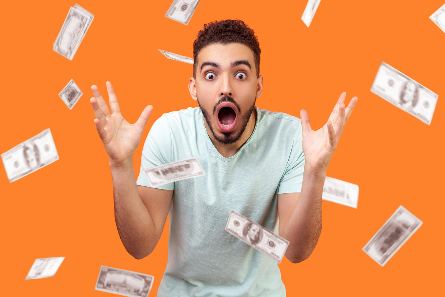 Oh my god, wow! Portrait of amazed man looking at camera with big eyes and open mouth, absolutely shocked of money rain falling from up.