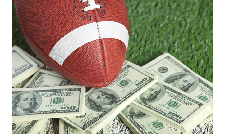 College style football on field with a pile of money