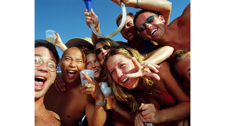 Group of young people wearing swimsuits, drinking beer, portrait