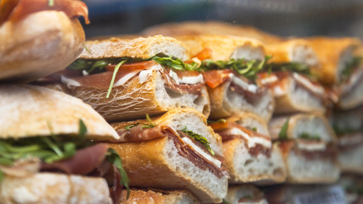 Panini made of arugula, tomato and prosciutto crudo