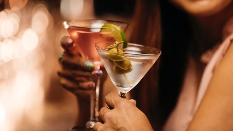 Woman toasting glasses with date at bar