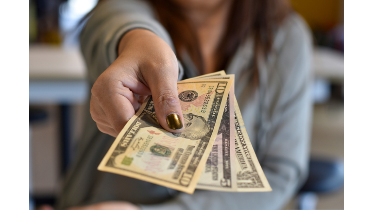 Midsection Of Woman Giving Paper Currency