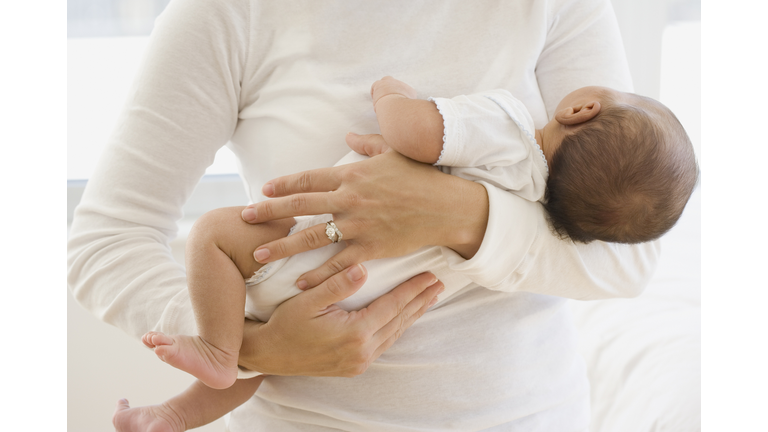 Close up of mother holding newborn baby