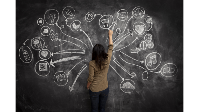 Girl drawing social meida icons on chalkboard