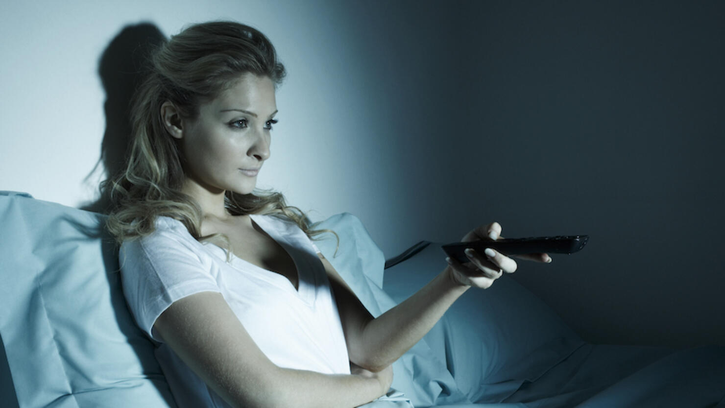 Woman watching TV in bed