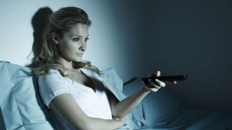 Woman watching TV in bed