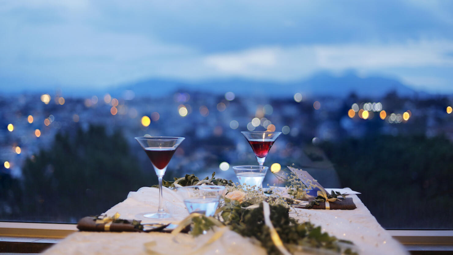 Glass of drink by the window with city background at night