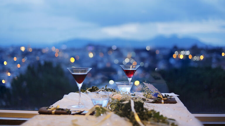 Glass of drink by the window with city background at night