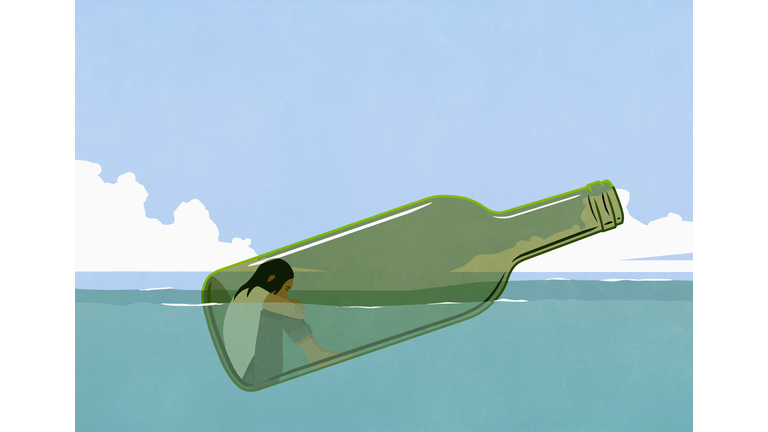 Depressed woman inside glass bottle floating in sea