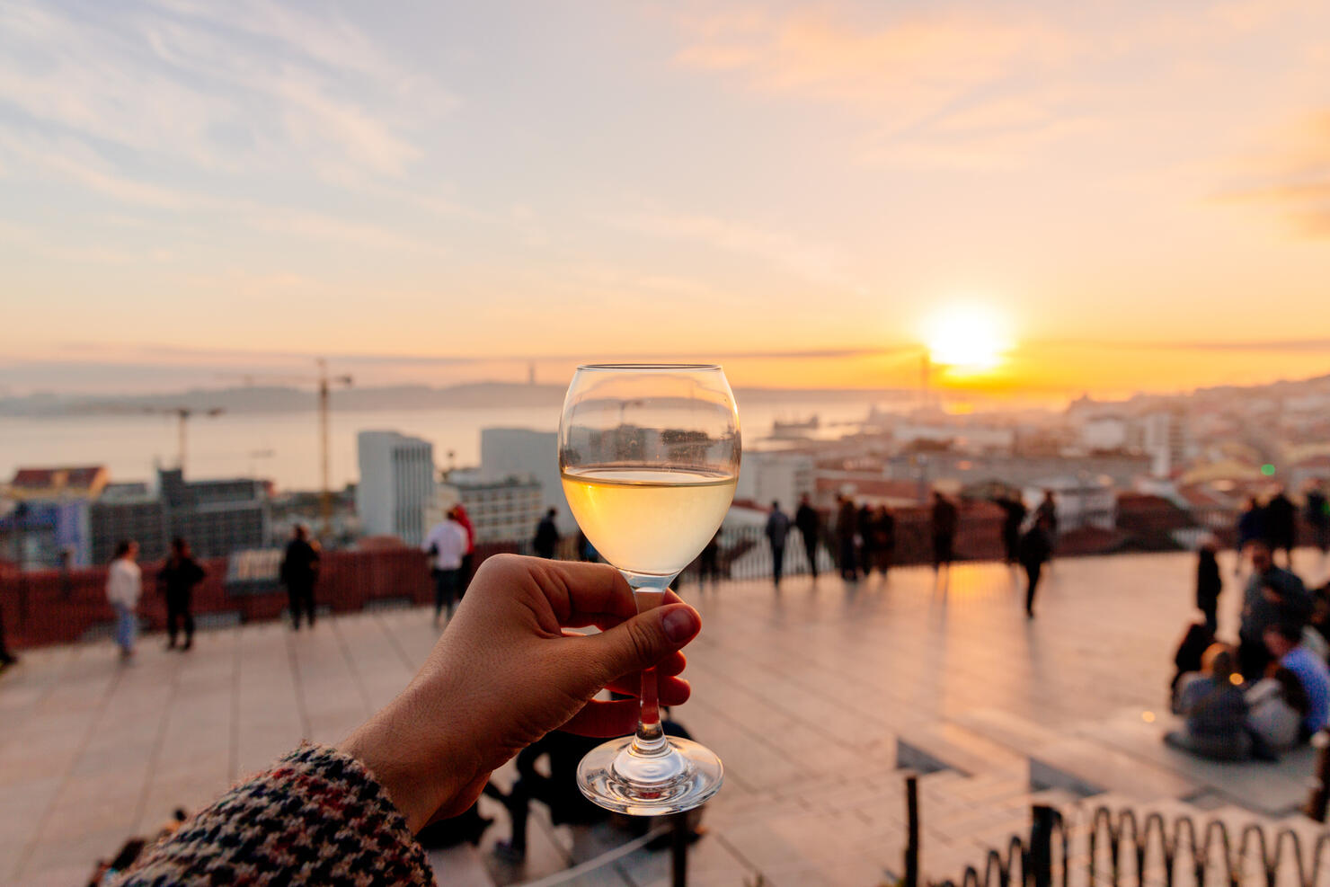 Drinking vinho verde (green wine) with view of Lisbon skyline at Miradouro de Santa Catarina, Portugal