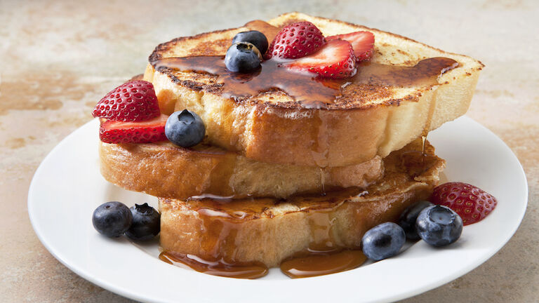 French Toast With Fruit and Syrup on a Marble Countertop.