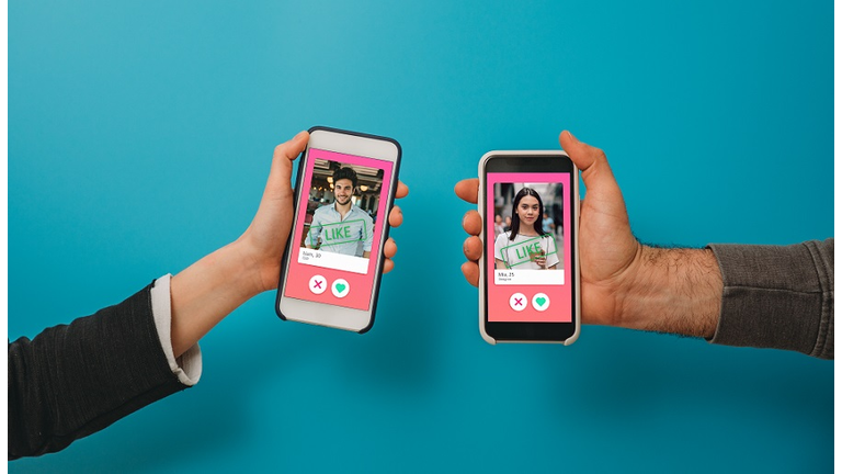 Conceptual image of two hands holding smart phones with an online dating app on the screen