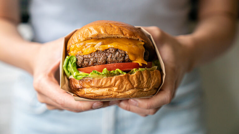 Midsection of woman holding burger
