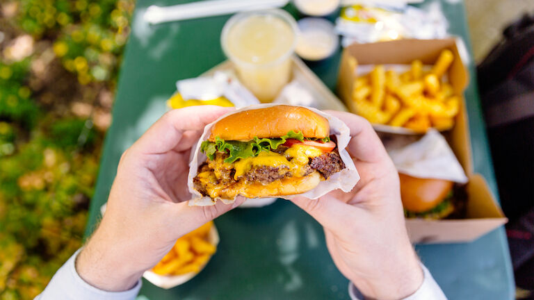 Man eating cheeseburger, personal perspective view
