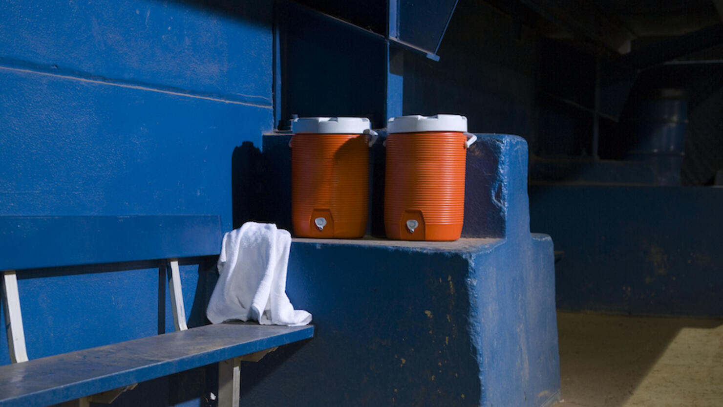 Empty baseball dugout with water coolers