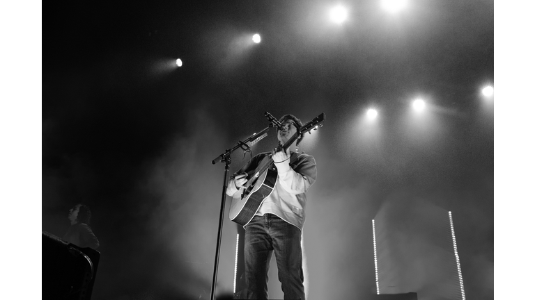 black and white film photo of singer with dramatic overhead light