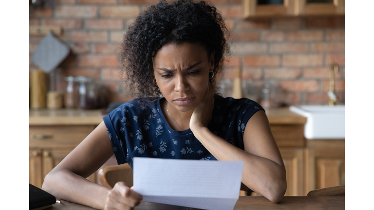 Close up unhappy African American woman reading letter, bad news