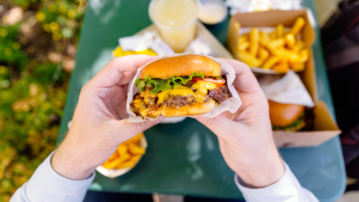 Man eating cheeseburger, personal perspective view