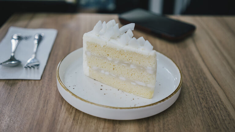 yummy vanilla cake on the wooden table with mobilephone