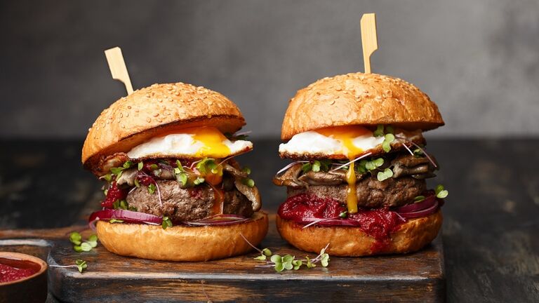 Junk food - homemade beef burgers on vintage wooden background