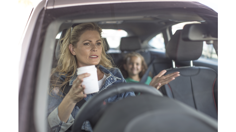 Serious woman and girl in car