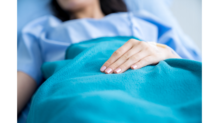 Close-up hands of patient recovering on the hospital bed
