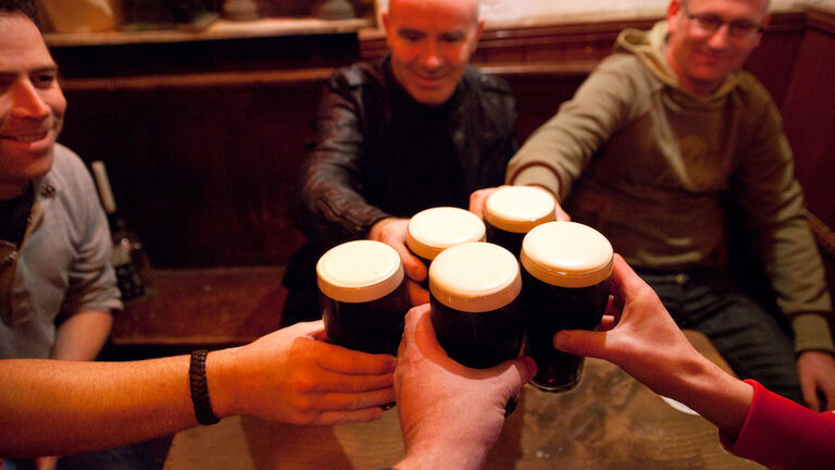 Men holding glasses of stout