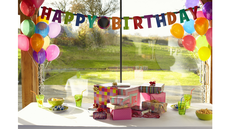 Table laid with birthday gifts and balloons