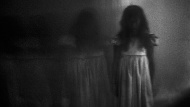 Double exposure of spooky girl against wall at home