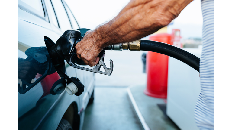 Close up senior man hands refueling his vehicle at gas station - Oil price increase concept
