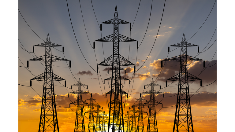 High voltage towers at sunset background. Power lines against the sky