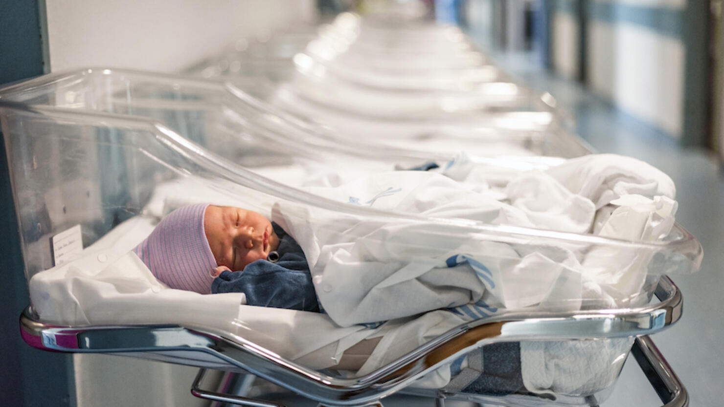 Newborn baby in first of many small hospital beds