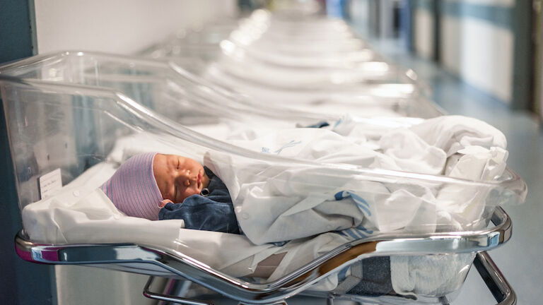 Newborn baby in first of many small hospital beds