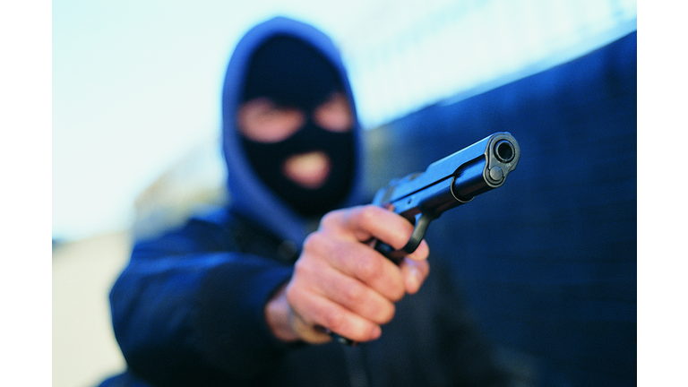 Male Criminal Wearing a Baraclava and Aiming a Gun