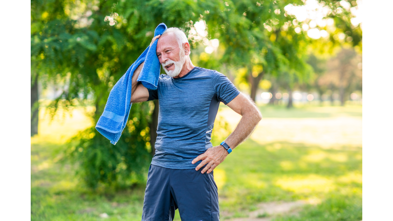 Senior man taking a break after exercising in the park.