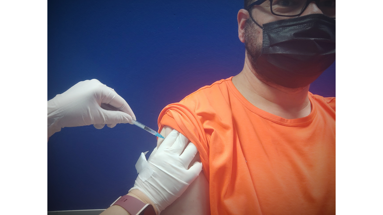 Young man receiving the injection of the coronavirus vaccine,vaccination shot by syringe with dose of medicine subcutaneous arm injection, by a doctor to receive the antibodies during COIVD-19 outbreak.