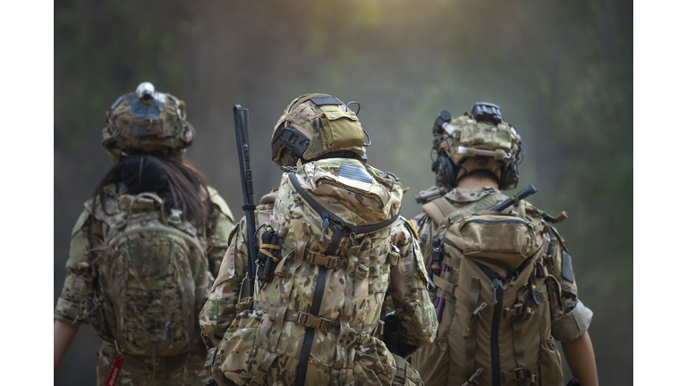 Rear of soldiers patrolling along the risky area.