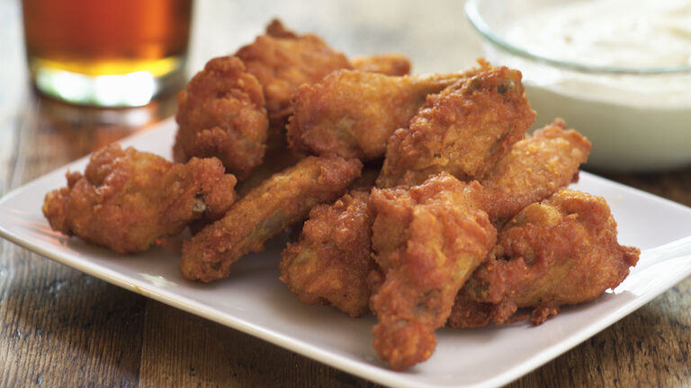 A plate of buffalo hot wings and a dip