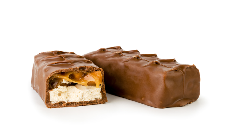 Chocolate Snickers and half close - up on a white. Isolated