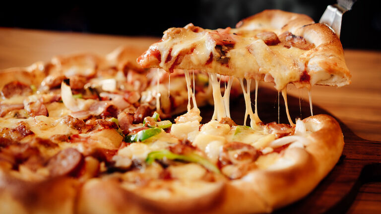 Slice of pizza cheese crust seafood topping sauce. with bell pepper vegetables delicious tasty fast food italian traditional and soft drink carbonated fresh on wooden board table classic in side view