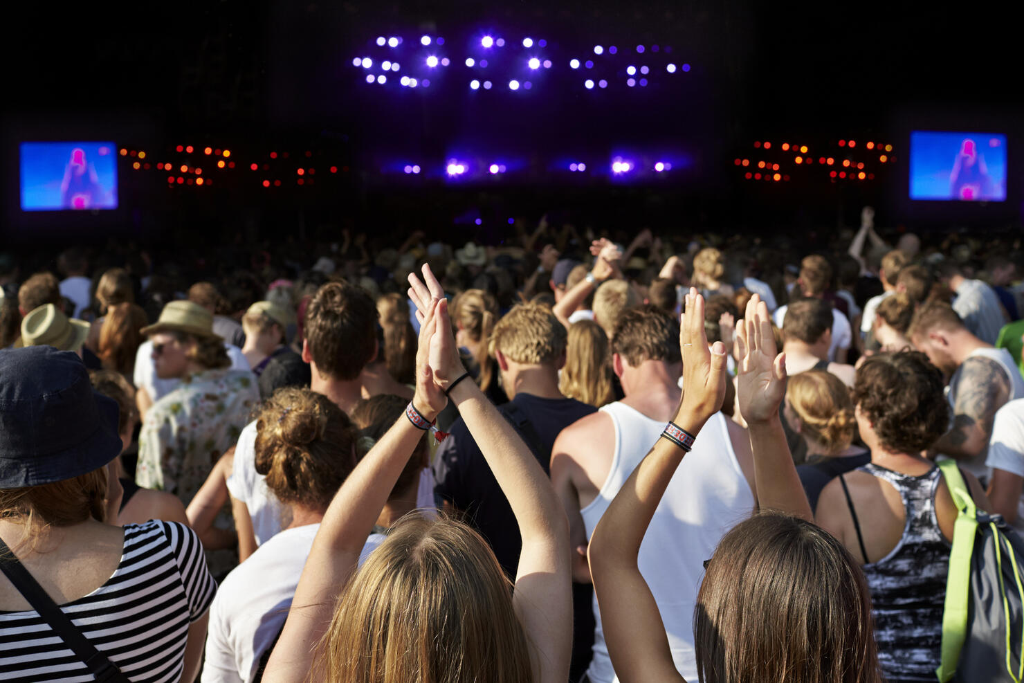 Women clapping hands at large concert
