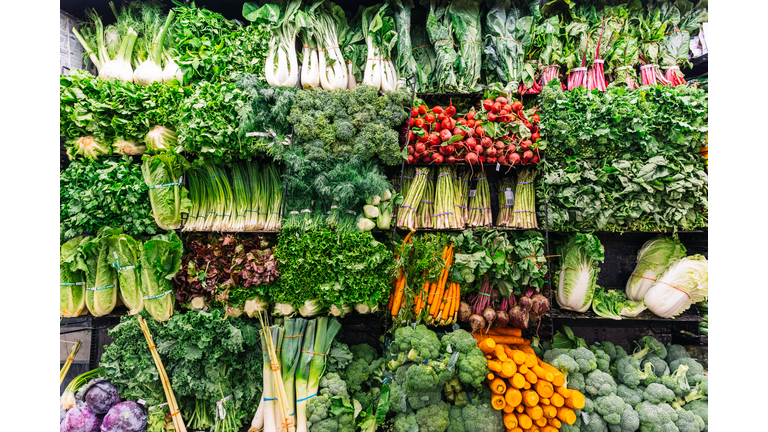 Fresh greens and vegetables on a display in a supermarket