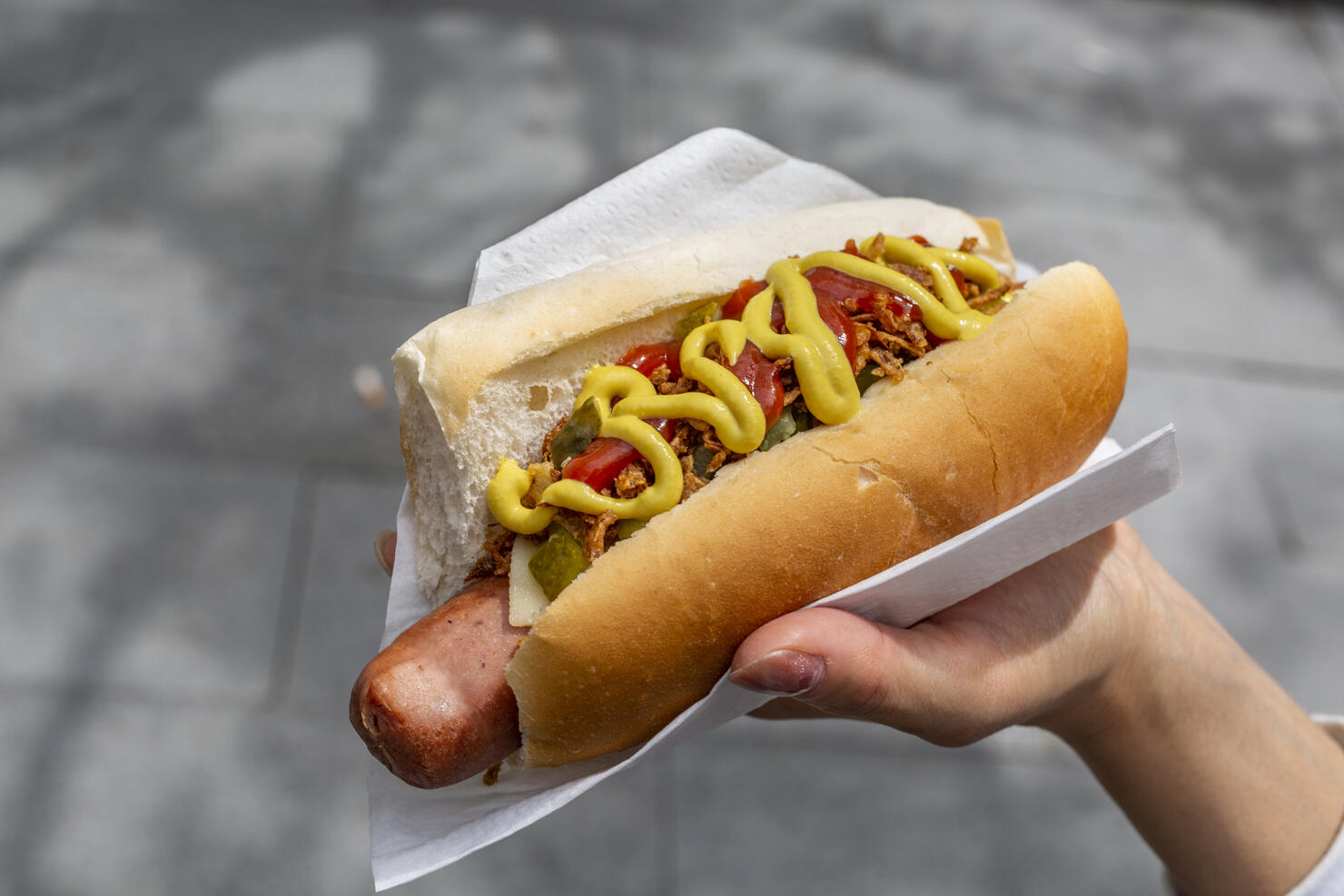 Woman's Hand holding hot dog