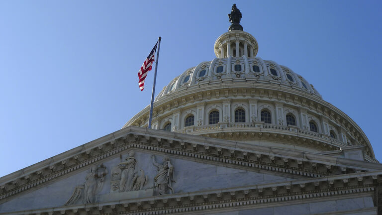 USA Capitol Building dome with American flag flying.