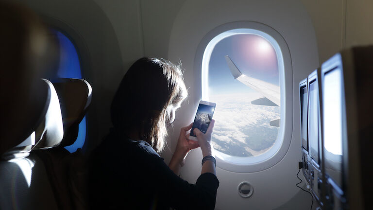 Girl taking photo out of airplane window