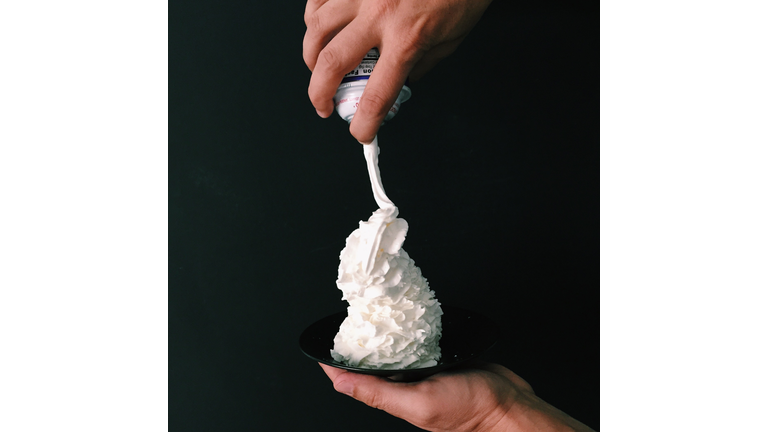 Hand holding a plate with whipped cream