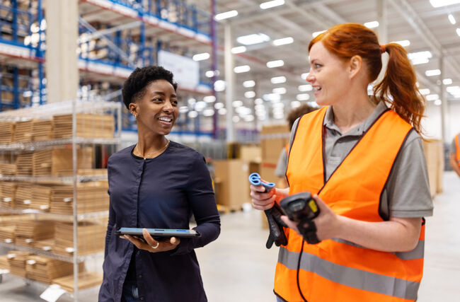 Manager walking and talking with a worker in a warehouse