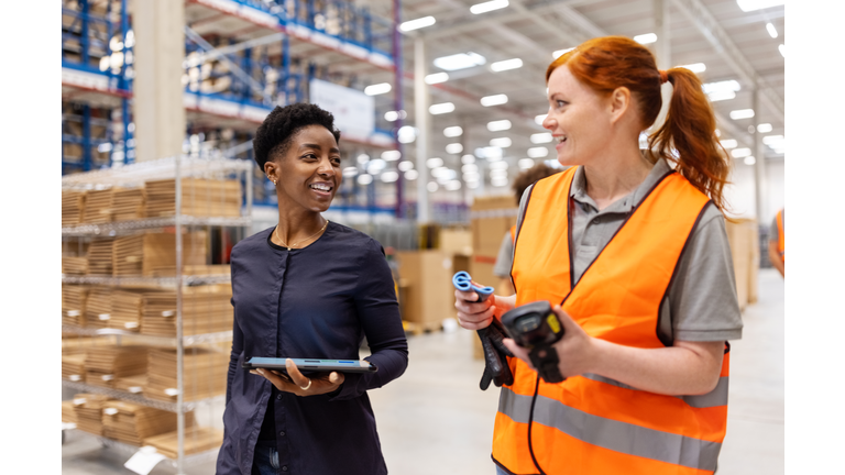 Manager walking and talking with a worker in a warehouse