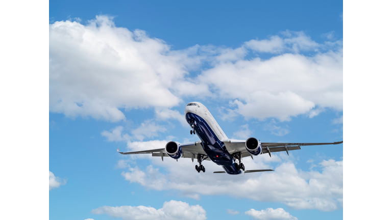 Close Up Tracking Shot of Plane coming into land with Blue cloudscape behind