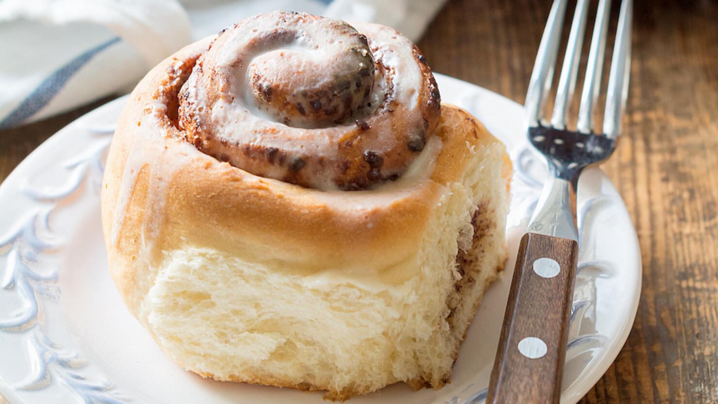 Cinnamon bun with cup of coffee, breakfast in cafe